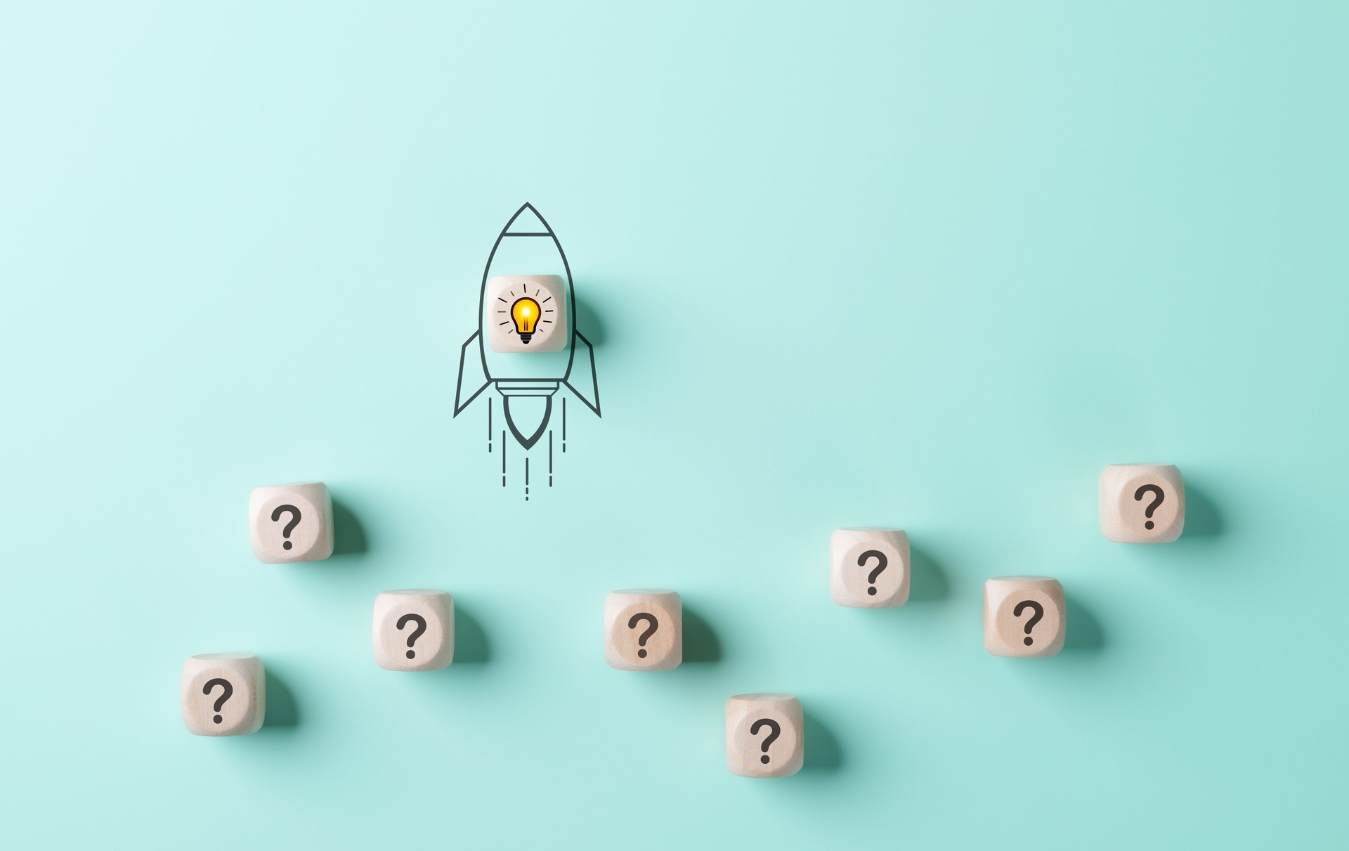 Problem solving and startup launch concept. A conceptual image of a rocket with a lightbulb taking off, surrounded by cubes with question marks on a light blue background. inspiration and innovation,